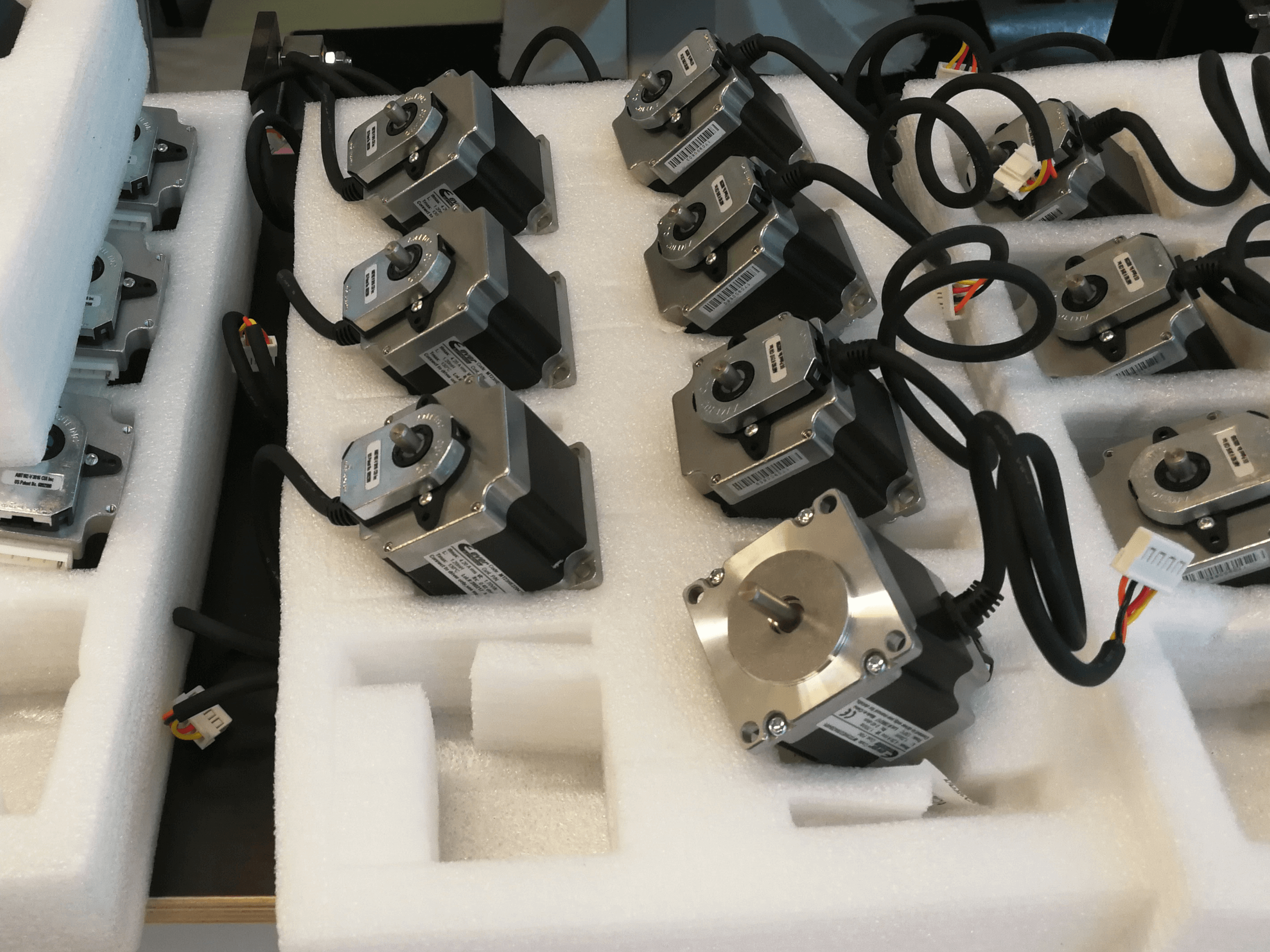 Stepper motors assembled with their respective rotary encoders arranged on foam containers