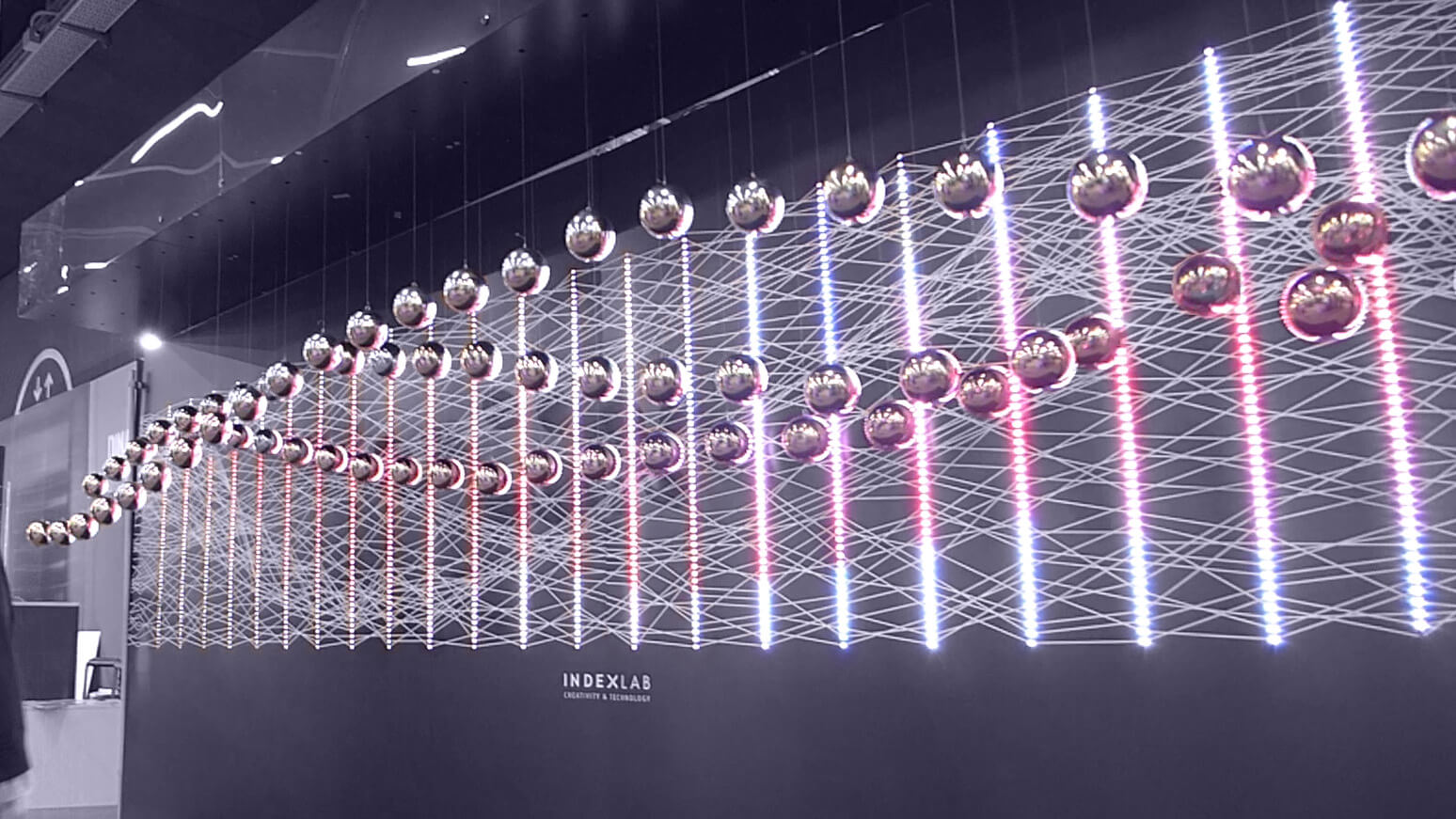 The flying Dots installation featuring suspended moving spheres on a dynamically lit background