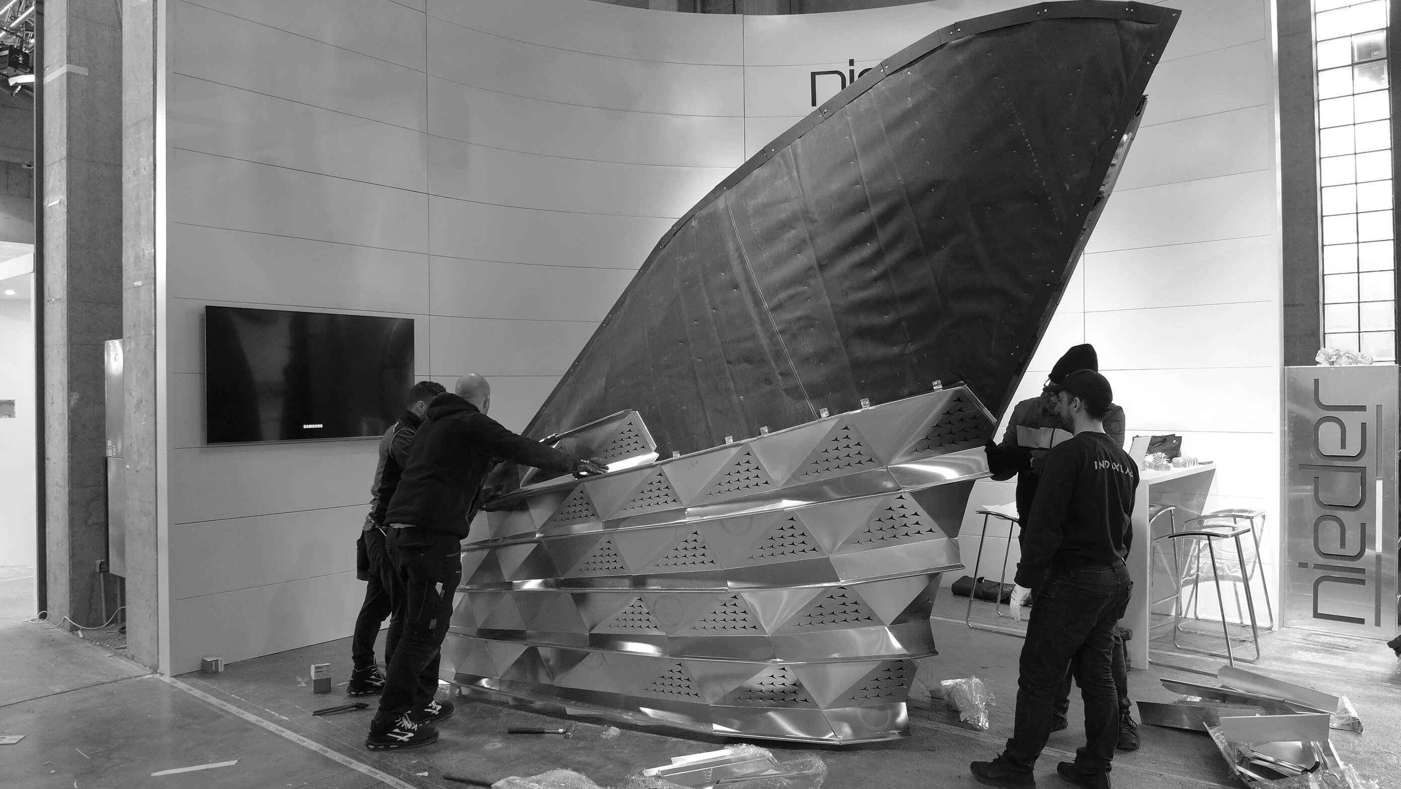 Workers assembling the fifth row of the SQUALO installation at Bolzano's faire