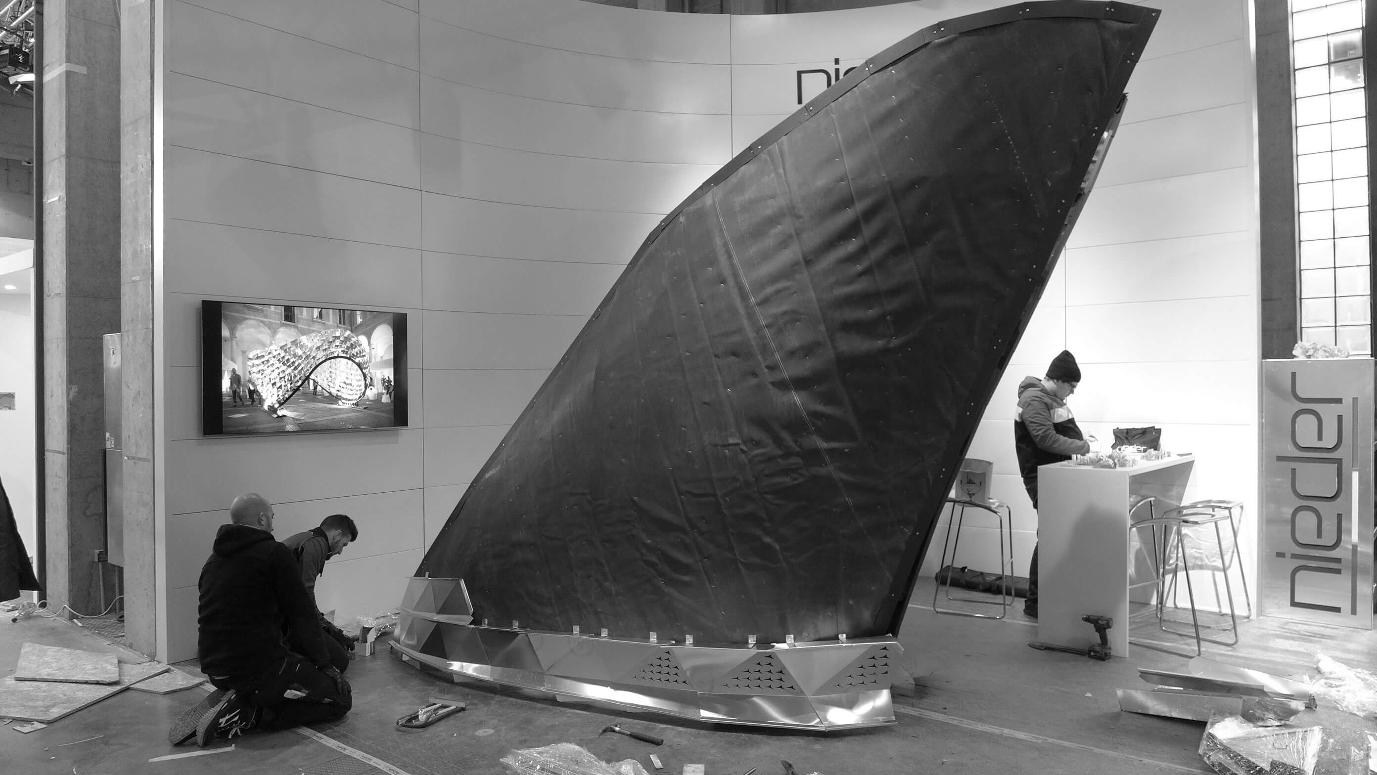 Workers assembling the second row of the SQUALO installation at Bolzano's faire